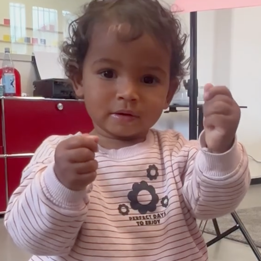 Baby zeigt mit den Händen eine Gebärde